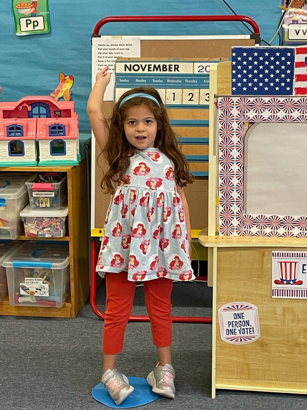 pre-school aged girl mock voting for Election Day